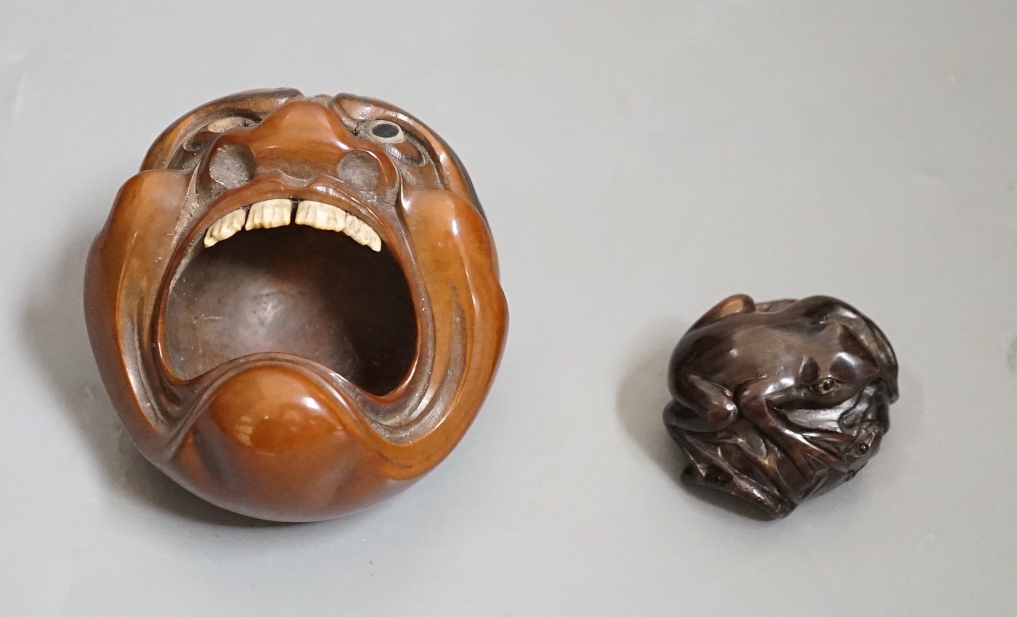 A Japanese mask nut carving wood carving, Meiji period and a netsuke of frogs, marks to bases, largest 7.5cm wide Ivory submission reference: 7BGTCJP8
